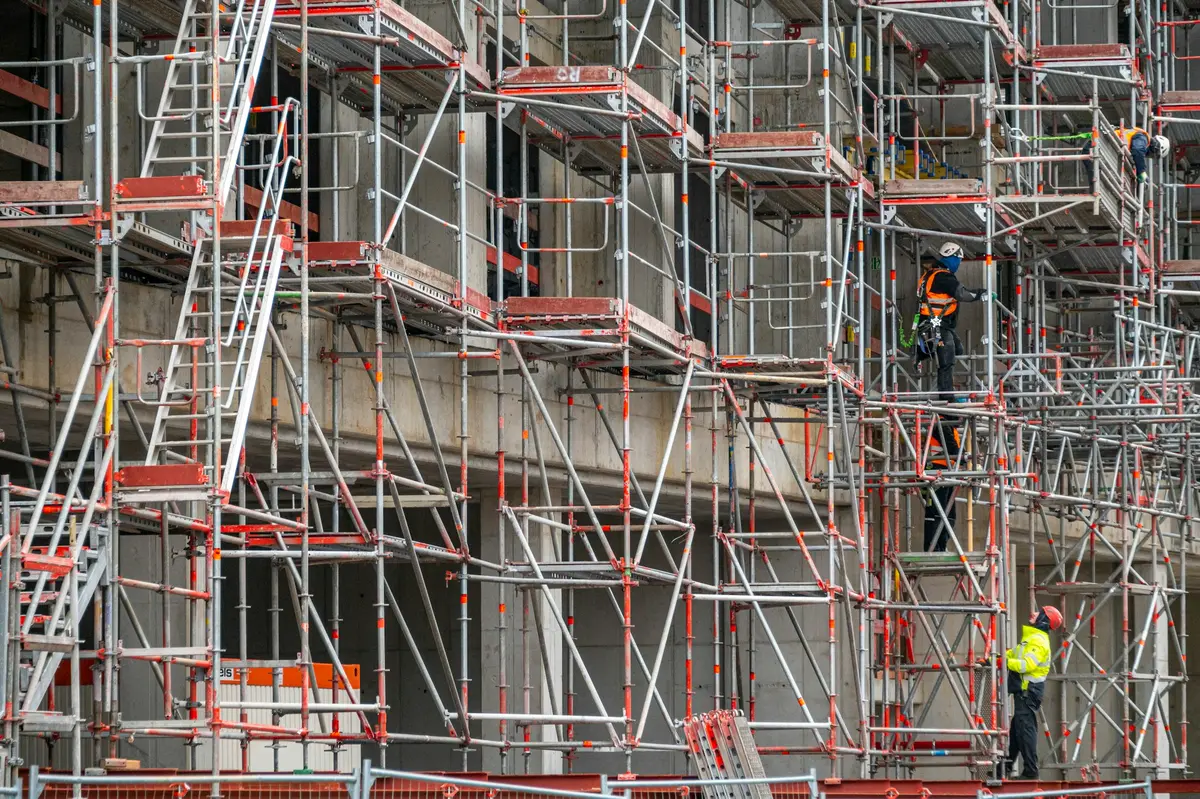 Scaffold frame and standards rising alongside a building under works